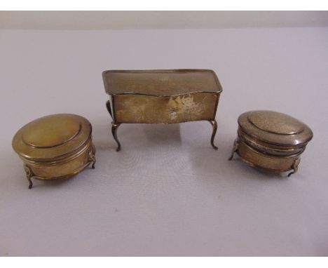 A silver rectangular jewellery casket with hinged engine turned cover on four scroll legs, London 1922 and two circular silve