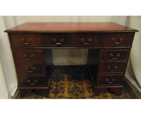 A mahogany rectangular pedestal desk with inlaid red leather top and brass swing handles on four bracket feet