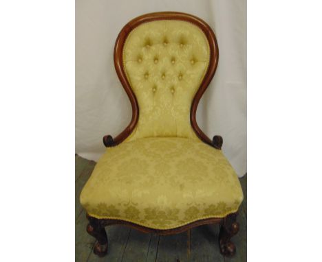 A Victorian spoon back upholstered salon chair with carved hardwood frame and button back
