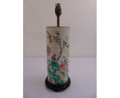 A famille verte cylindrical table lamp decorated with flowers and birds on hardwood stand