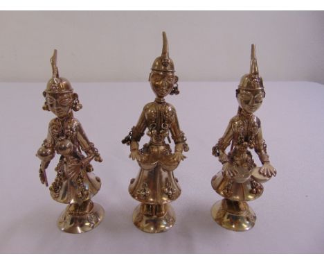 Three white metal Far Eastern figurines playing a variety of musical instruments on raised circular bases