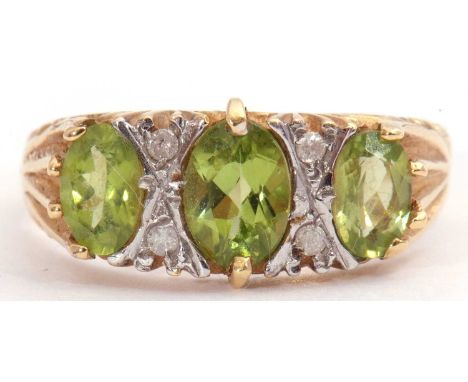 Modern peridot and diamond ring featuring three graduated oval shape peridots, highlighted between with small round cut diamo