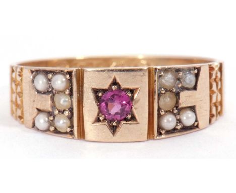 Antique 9ct gold ruby and seed pearl ring centring a round cut ruby in a star engraved setting, between seed pearl set should