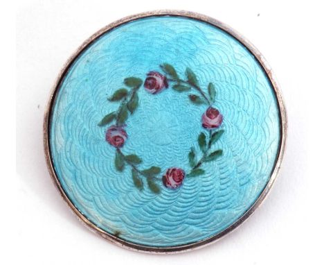 Antique silver and enamel brooch of circular shape, a light blue guilloche enamel ground decorated with a garland of leaves a