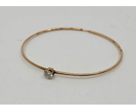A precious yellow metal and diamond bangle, claw set single round brilliant cut diamond (estimated diamond weight 0.50 carats