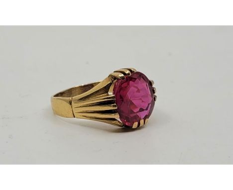 A precious yellow metal and ruby ring, set large mixed oval cut ruby to centre (12mm x 11mm x 5mm, ETW 4.5 carats), with ribb
