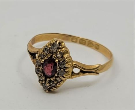 A Victorian 18ct. yellow gold, ruby and diamond ring, having marquise head set central mixed oval cut ruby bordered by diamon