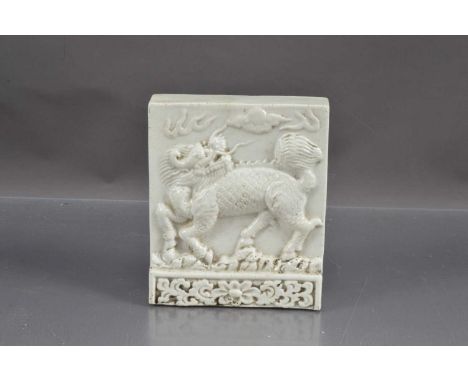 A antique Chinese white glazed dragon tile, 13.5cm x 11.5cm x 4cm deep max.