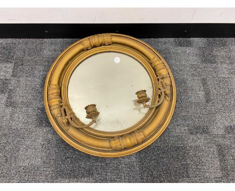 An Edwardian gilt girandole mirror, circular with brass candle sconces. 52 cm diameter (mirror and frame)PLEASE SEE ADDITIONA