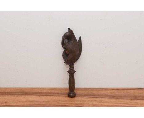 A circa 1930s Black Forest carved novelty nutcracker, carved in the form of a squirrel eating a nut, 21cm high (ear af)