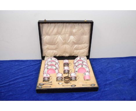 An Edwardian Aynsley porcelain and silver coffee set in case, one demi-tasse cup broken, with silver holders and coffee spoon