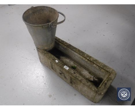 A stone plant trough and a galvanized bucket 