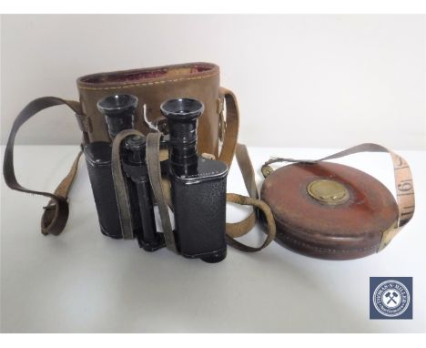 A pair of leather cased Chevalier binoculars together with a vintage leather cased tape measure by Chesterman of Sheffield