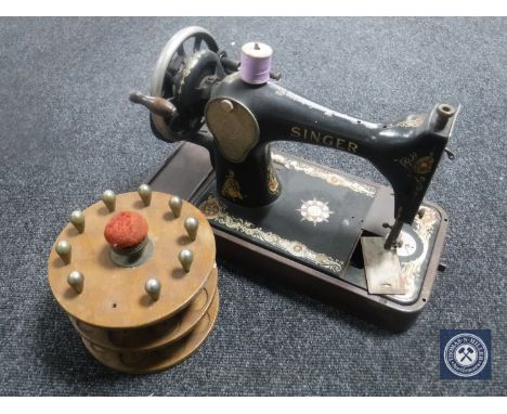 A vintage Singer hand sewing machine together with a bobbin stand
