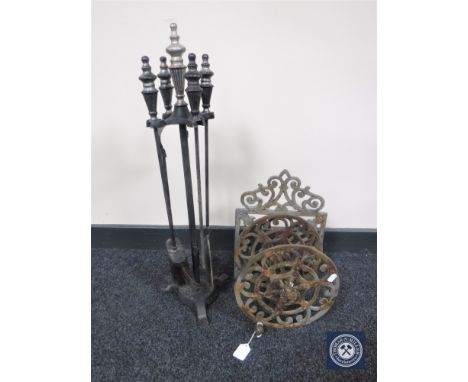 A four-piece companion set on stand, together with a cast iron wall mounted hose-pipe reel