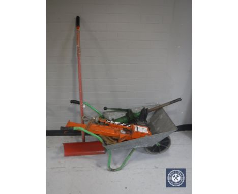 A wheel barrow containing Lucas swing lift, pump, and a snow shovel  