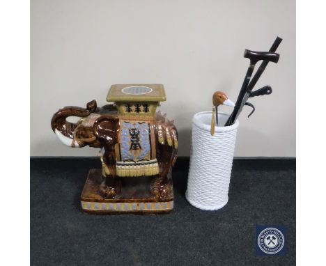 A glazed ceramic elephant plant stand together with a stick stand of assorted walking sticks and umbrellas etc