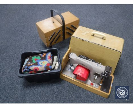 A cased Singer electric sewing machine, sewing box and bucket of tapestry and large quantity of buttons 