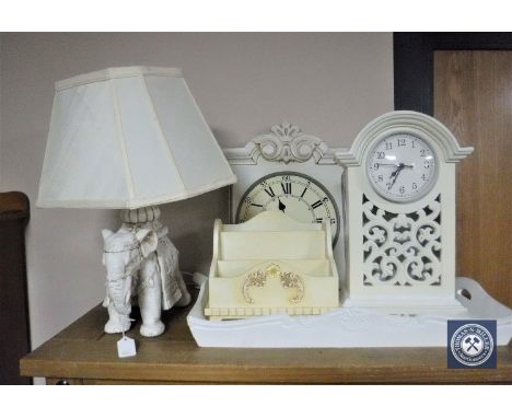 A white wooden elephant table lamp with shade, serving tray, correspondence stand, wall clock and mantel clock 