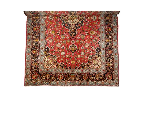 TABRIZ STYLE SMALL CARPET, the central rectangular madder ground with a dark blue and ivory quatrefoil medallion surrounded b