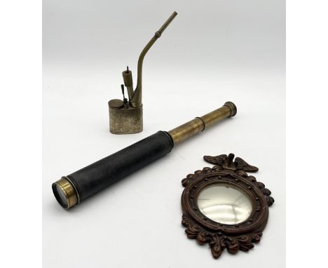 An antique brass opium pipe along with a four drawer telescope and small porthole mirror with eagle decoration