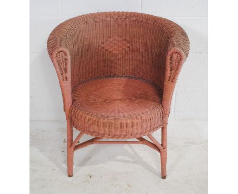 A pink Lloyd Loom style tub chair