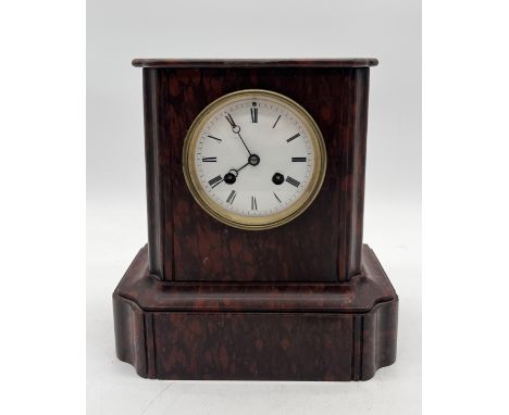 A heavy hardstone mantle clock, possibly red marble, mechanism in need of some attention