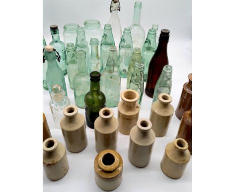 A collection of assorted vintage and antique glass and stoneware jars and bottles, many named, contained in a wooden crate.
