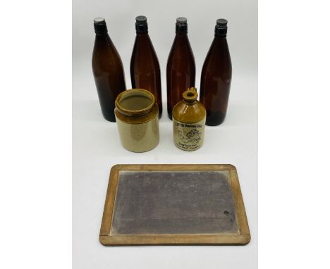 Four vintage brown bottles, along with a small stoneware flagon, stoneware jar and blackboard
