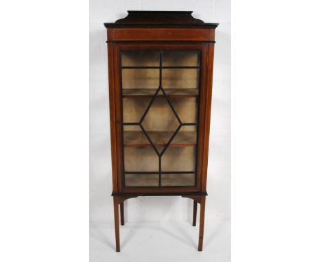An Edwardian inlaid mahogany display cabinet, with astragal glazed door and boxwood stringing, raised on stick legs - with ke