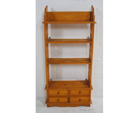 A pine wall shelf, with pierced decoration and four drawers under - length 51.5cm, depth 19cm, height 110.5cm