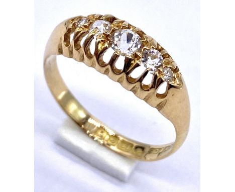 An 18ct gold boat ring set with five graduated diamonds, size M 1/2