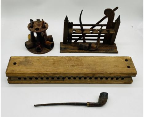 A wooden cigar mould marked with Reichling & Eberhard, along with a selection of vintage smoking pipes, housed in stands