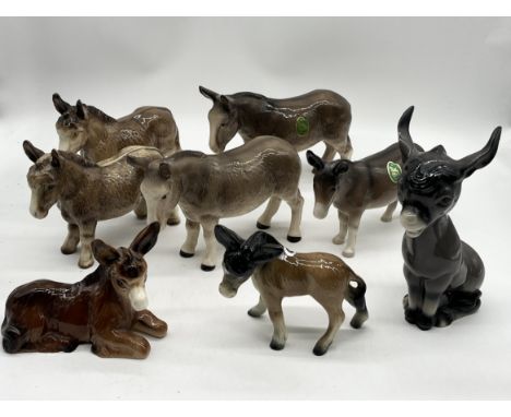 A collection of various donkey figurines including a number of Melba Ware examples