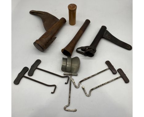 A collection of antique leather hunting horn cases along with two pars of rosewood handled boot pulls etc.