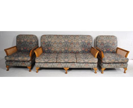 A bergère three-piece suite, consisting of a three-seater sofa and a pair of armchairs
