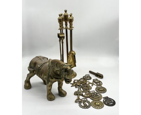 A heavy brass model of a shire horse along with a fireside set and collection of horse brasses