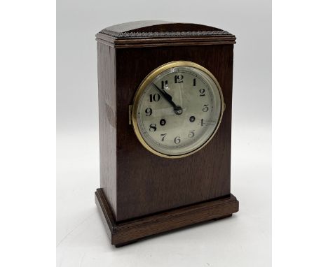 An oak cased mantle clock with domed top