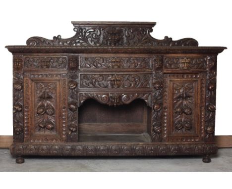 A 19th Century Cromwellian style Sideboard, with low shaped and carved back depicting a central grotesque mask over a base wi