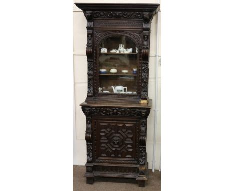 A 19th Century Cromwellian style carved oak Display Cabinet, the plain moulded cornice over a single glazed arch door, flanke