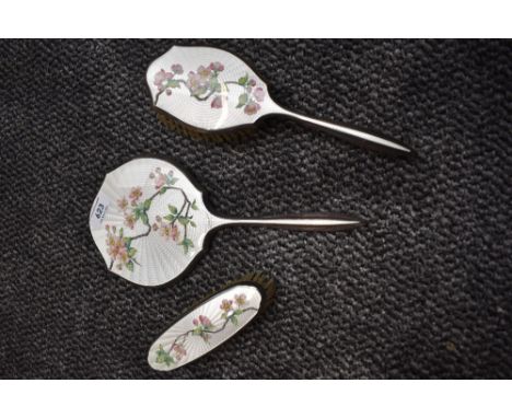 A mid century silver plated dressing table set having enamel guilloche backs over painted with pink apple blossom, thought to