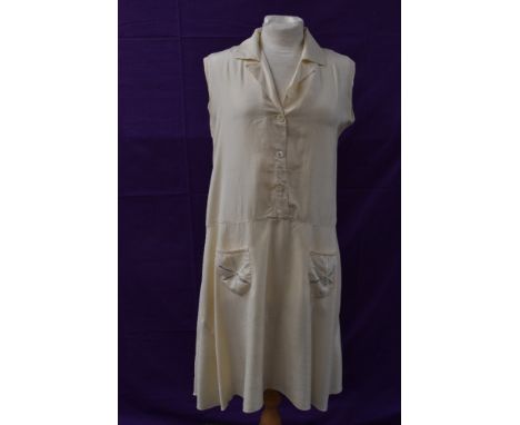 A cream silk 1920s day dress having button front and dropped waist with embroidered floral details to pockets.