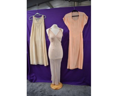 Three vintage nightdresses, one beautiful bias cut 1930s in a semi sheer fabric with delicate dot pattern on a pale pink grou