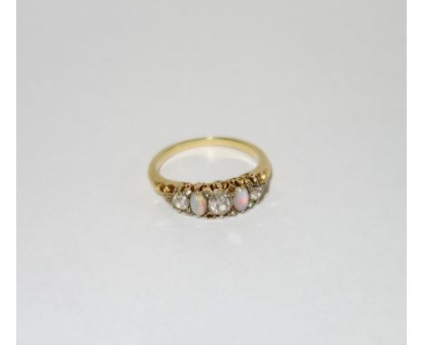 A DIAMOND AND OPAL DRESS RING, on an unmarked yellow metal shank, ring size L