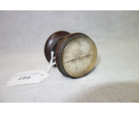 A TABLE COMPASS, set in a wooden frame with a tripod base, 5 cm high