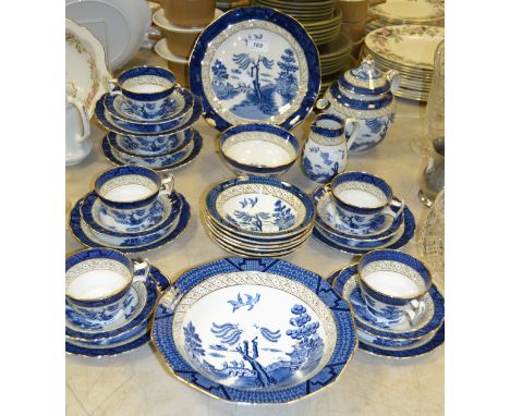 A Booths Real Old Willow pattern tea service comprising of a teapot, sugar bowl, milk jug; cups, saucers, side plates, desser