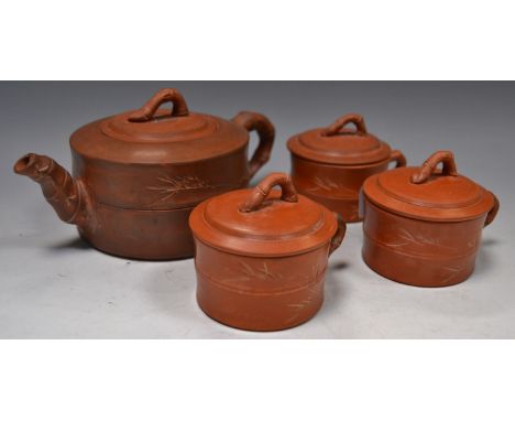 A Yixing type terracotta teapot, inscribed in script; three conforming tea bowls with covers (4)