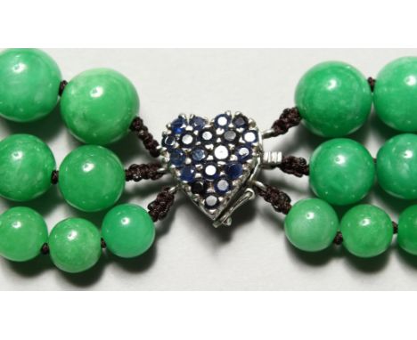 A JADE BEAD NECK with 14ct white gold and sapphire clasp.