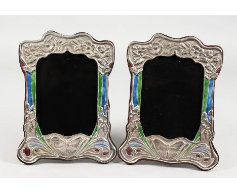 A PAIR OF ART NOUVEAU STYLE SILVER PHOTOGRAPH FRAMES, with enamel decoration, embossed with a butterfly design. 8.25ins x 6.2