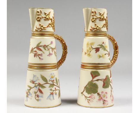 A PAIR OF ROYAL WORCESTER  IVORY CLARET JUGS, gilded and painted with flowers on an ivory ground, date code for 1890, matchin